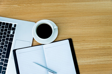 Desk with laptop, coffee,  pen and notebook