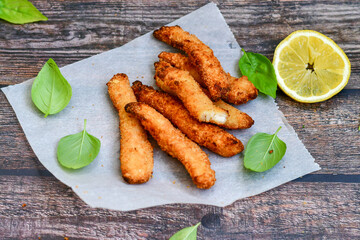 
 Crispy  deep fried   chicken strips and wedges potato. Breaded  with cornflakes chicken  breast fillets  with chilly peppers and fresh   basil on wooden rustic background