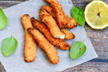 
 Crispy  deep fried   chicken strips and wedges potato. Breaded  with cornflakes chicken  breast fillets  with chilly peppers and fresh   basil on wooden rustic background