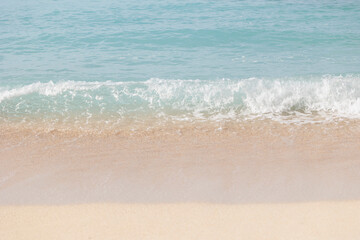 Fototapeta na wymiar 穏やかな波の明るいビーチ
