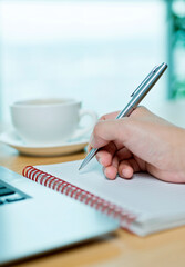 People using laptop and writing notebook at workplace