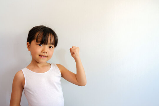 A photo of a half-up girl raising her hand during a morning workout with a bright face in an intense competition.
