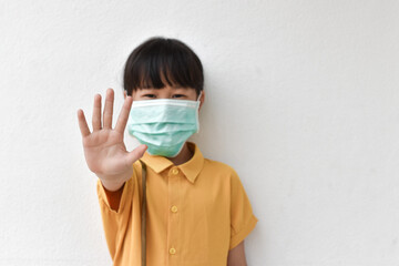 A photograph of a girl showing a hand sign, do not approach. on the plaster floor Indicates protection from viral diseases by wearing a mask during intimacy.