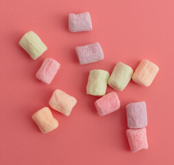 Multicolored candies on a pink background. Close-up