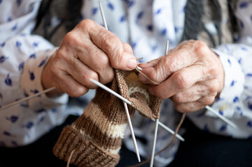 Close up of the hands of an elderly woman knitting sock