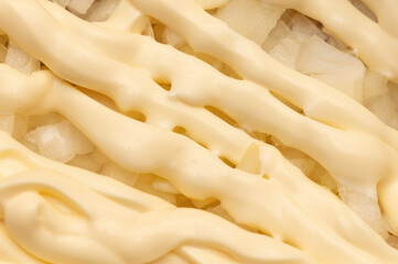 Mayonnaise on onions in a salad.