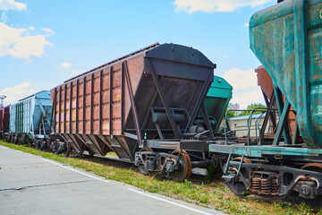 Freight cars are parked and waiting for loading with industrial goods. Transportation of various materials