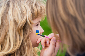 Sign of ukrainian flag on child cheek. Activism concept.