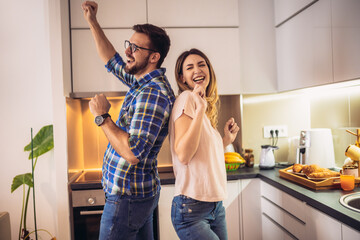 Loving couple dancing together in kitchen at home