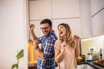 Loving couple dancing together in kitchen at home