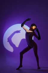 Fototapeta premium glamorous woman scene spotlight posing neon purple background unaltered
