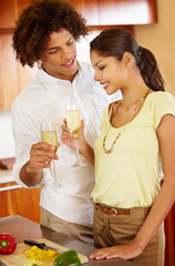 To our life together. A young couple toasting each other in their kitchen.