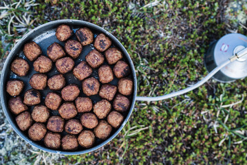 Cooking Swedish meatballs on outdoor kitchen