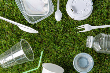 recycling, environment and ecology concept - close up of plastic waste on grass