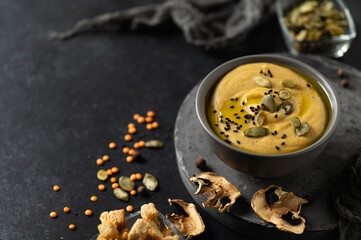 cream soup vegetarian vegetable with lentils and champignons on a dark background with seeds and croutons