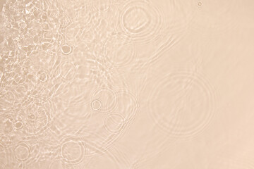 Transparent beige clear water surface texture with ripples, splashes and bubbles. Abstract nature...
