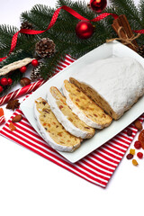 Fototapeta na wymiar Sliced Traditional Christmas stollen cake with marzipan and dried fruit isolated on ceramic plate