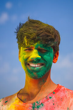 Portrait of a boy with his face covered in holi colors. joy of playing holi. Holi and festival concept.