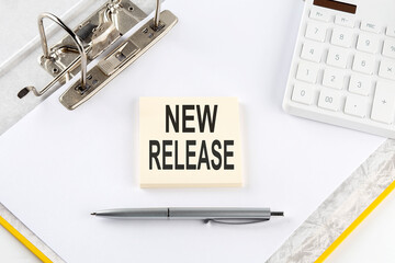 NEW RELEASE - business concept, message on the sticker on folder background with calculator