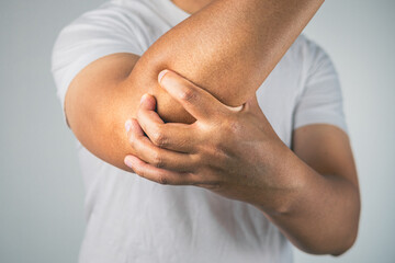 The man pains elbow. These symptoms may cause by sport, hard work with arm. Close up shot.