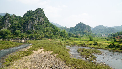 Naklejka na ściany i meble Green hill and mountains near rice fields in Bac Son Valley, Vietnam.