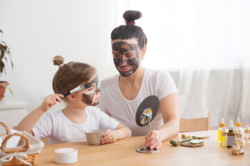 Morning skin care. mom and little daughter have fun spending time together at home. Happy family mother and child daughter make face skin mask together. 