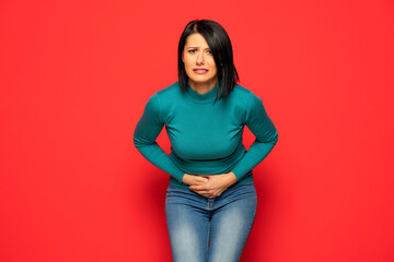 Middle aged woman having painful stomachache with hands holding pressing her crotch lower abdomen. Medical or gynecological problems