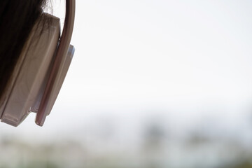 Rear view of woman with headphones looking on palm trees sea beach at sunset. Female relaxing listenning music.
