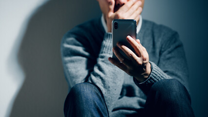 精神障害を患っている男性がスマートフォンを使っている