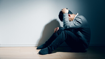 精神障害を患っている男性が膝を抱えている