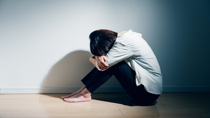 精神障害を患っている若い女性が膝を抱えている - obrazy, fototapety, plakaty