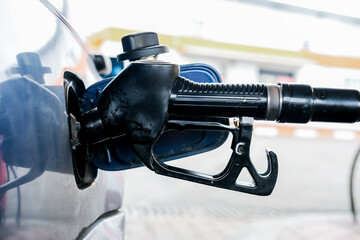 refueling gun in the gas tank of the car