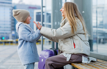 Mom and daughter are sitting at the bus stop