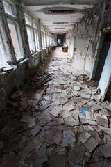 Corridor filled with damaged books in a school in the city of Pripyat