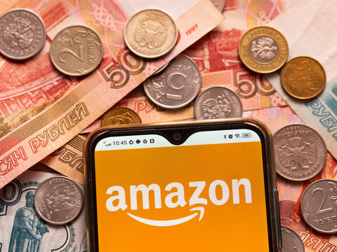 In this photo illustration, the Amazon logo is displayed on a smartphone on the background of Russian money.