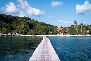 Floating bridge to beautiful beach. Clear blue water