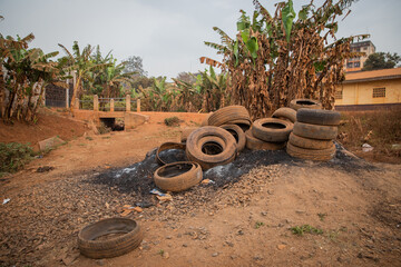 Used tires left in an illegal open landfill near houses in Africa, concept of pollution in Africa
