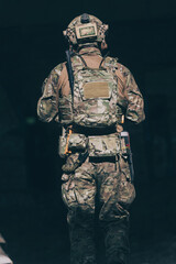 A bearded soldier in uniform of special forces in a dangerous military action in a dangerous enemy area. Selective focus 