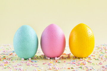 Easter eggs in pastel colors on a yellow background
