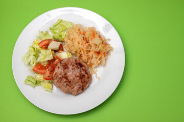 grilled hamburger with salad and salted salas cabbage with carrot on white plate