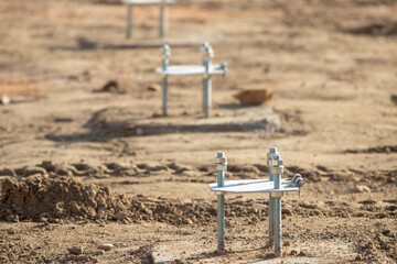 Concrete anchors in ground on sunny day