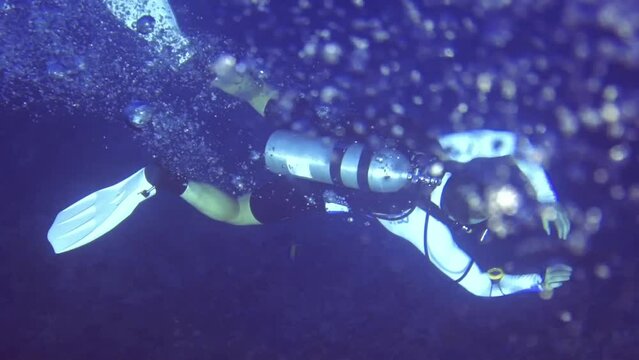 oxygen bubbles cover diver near coral reef. Maldives