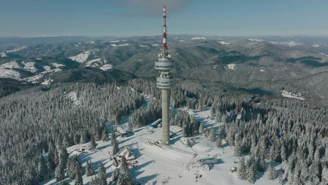 4K Aerial winter view of Rhodope Mountains and Snezhanka tower near resort of Pamporovo, Smolyan Region, Bulgaria
