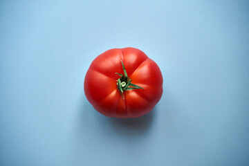 czerwony pomidor na niebieskim tle  - obrazy, fototapety, plakaty