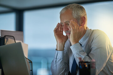 Its been a challenging day. Cropped shot of a mature businessman looking stressed out at his desk.