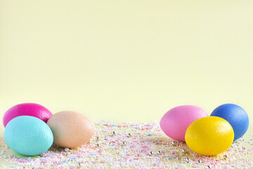 Easter eggs in pastel colors on a yellow background, place to test
