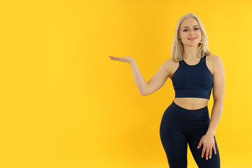 Concept of healthy lifestyle with sporty woman on yellow background