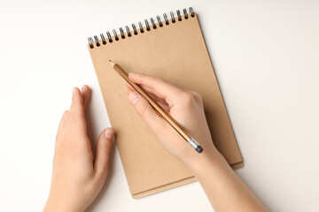 Female hands write in craft notebook on white background