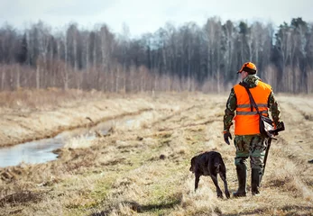 Tuinposter Pheasant hunting, hunter with dog © Zhanna