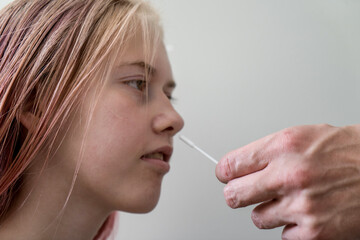 Teenage girl while doing rapid antigen test nasal swab. Rapid diagnostic test kit